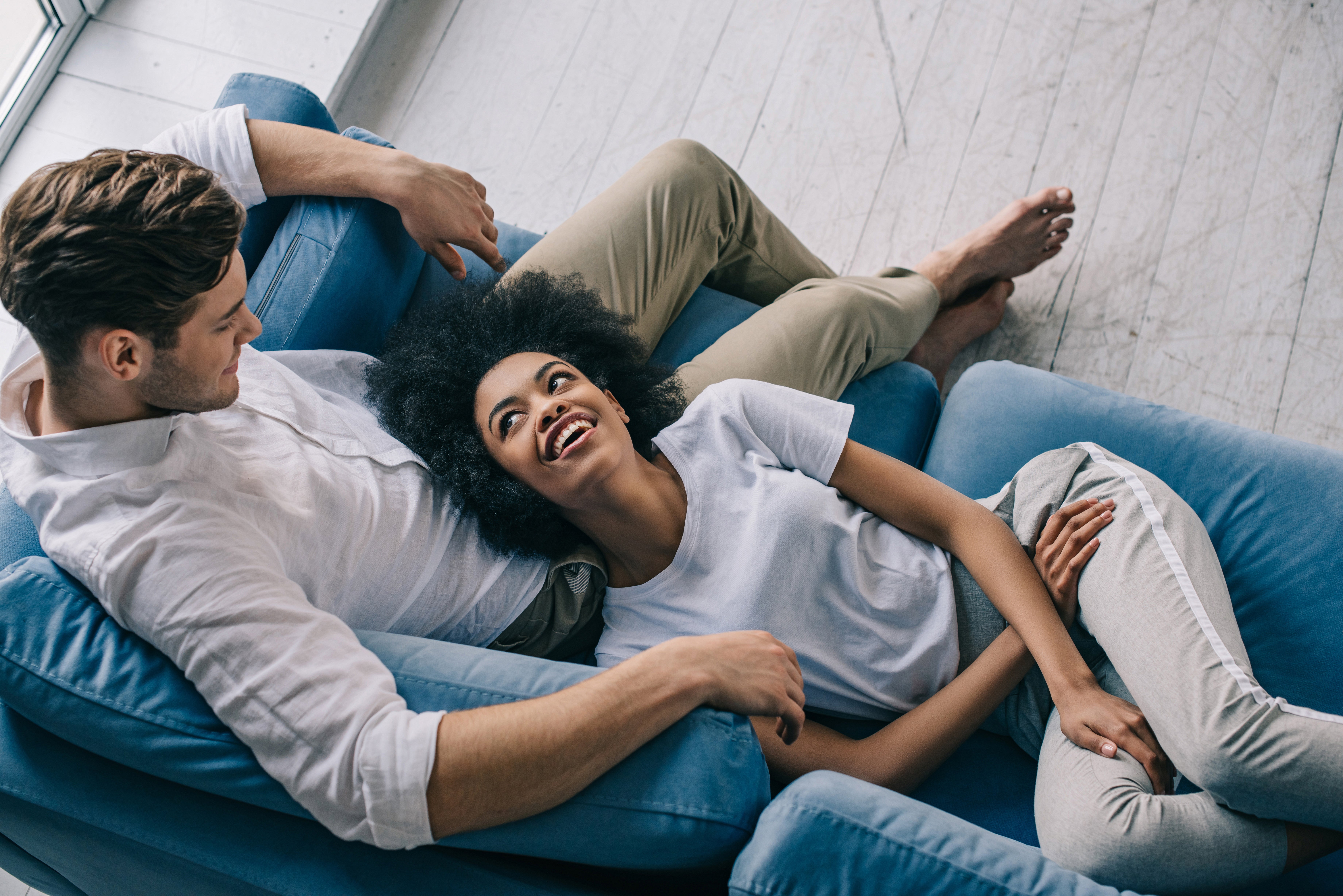 un-couple-heureux-se-détendre-sur-le-canapé-et-souriant