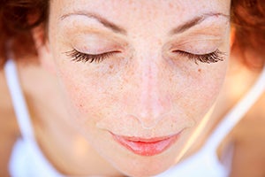 A women closing her eyes and meditating 