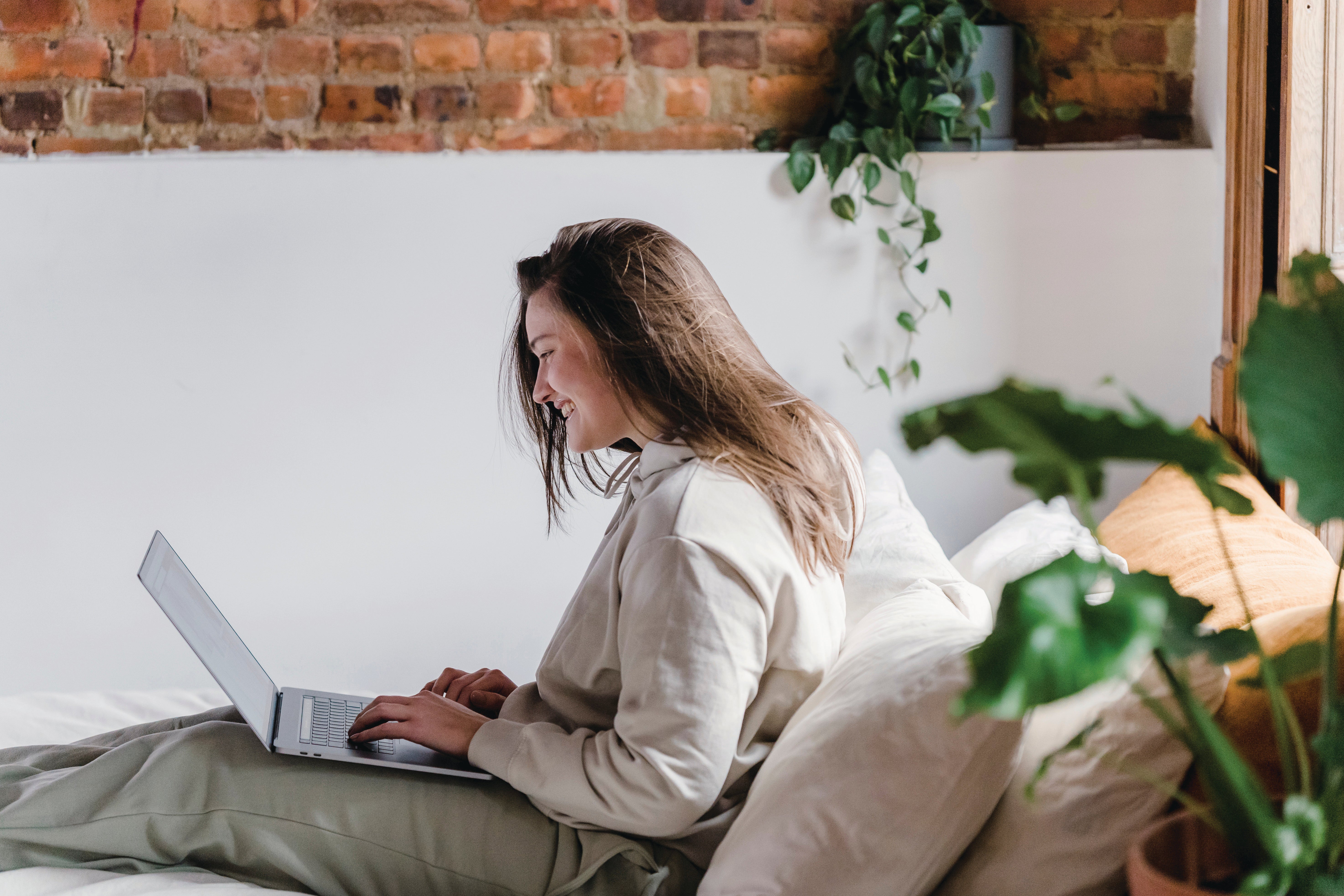 Women working on laptop from bed