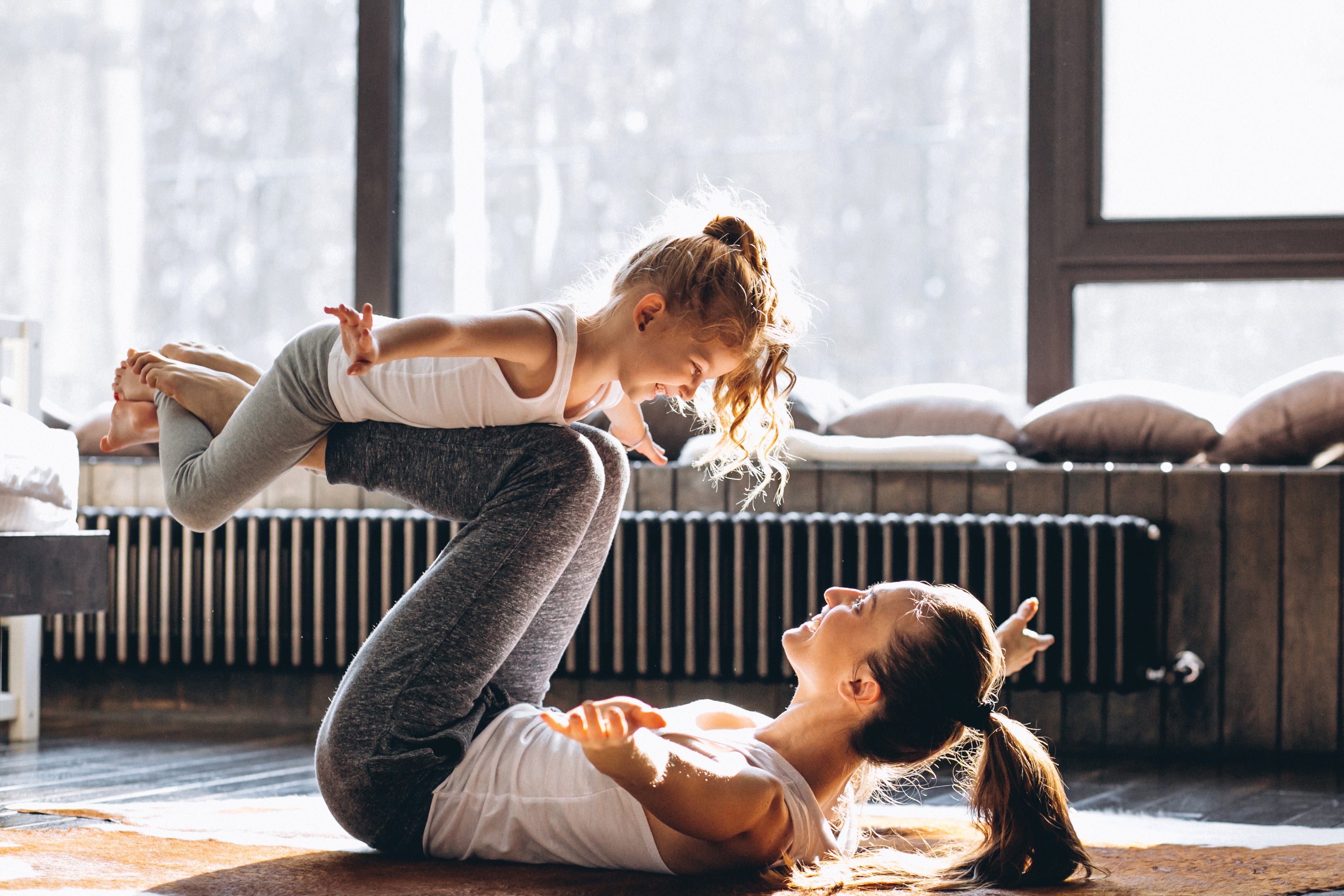  Femmes équilibrant leur fille sur ses jambes et jouant