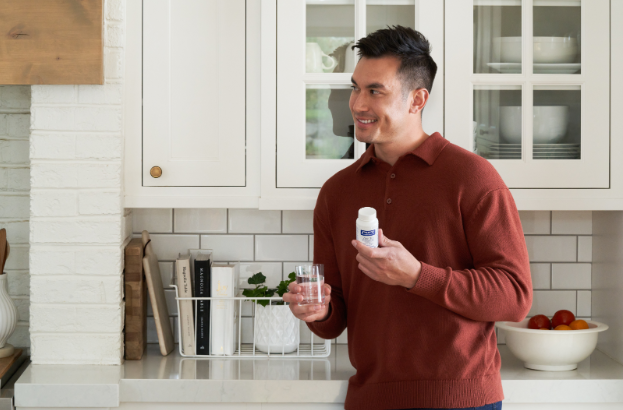 Homme prenant ses suppléments Pure Encapsulations avec de l’eau