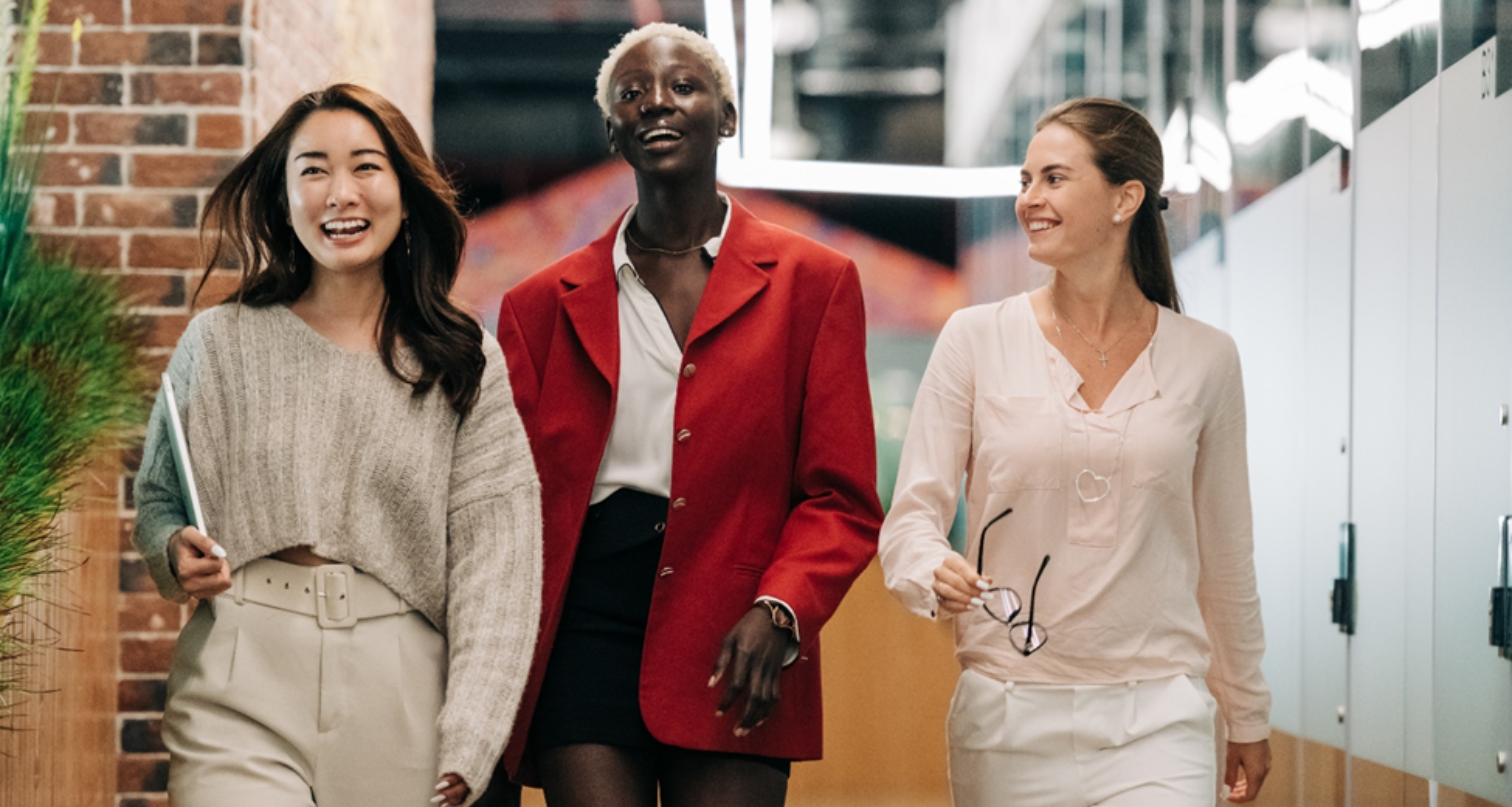 Trois femmes marchant, parlant et souriant