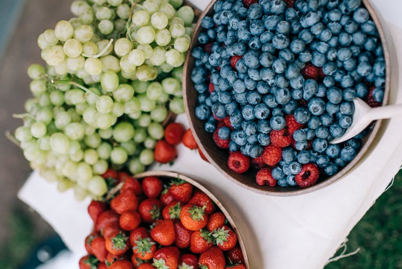  Bol de fraises, myrtilles, framboises et raisins verts.