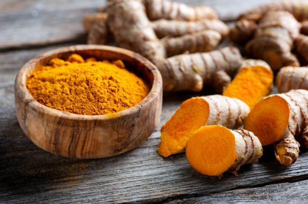 Tumeric root and powder on a kitchen counter. 