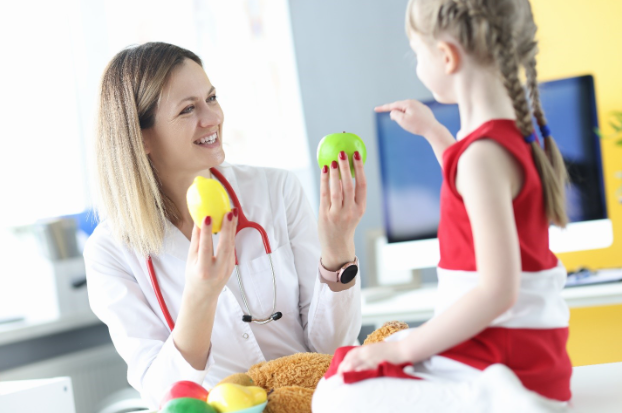 Women doctor teaching a child about healthy food.