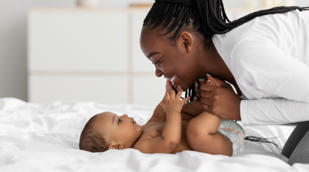 A mother smiling with her new born baby.