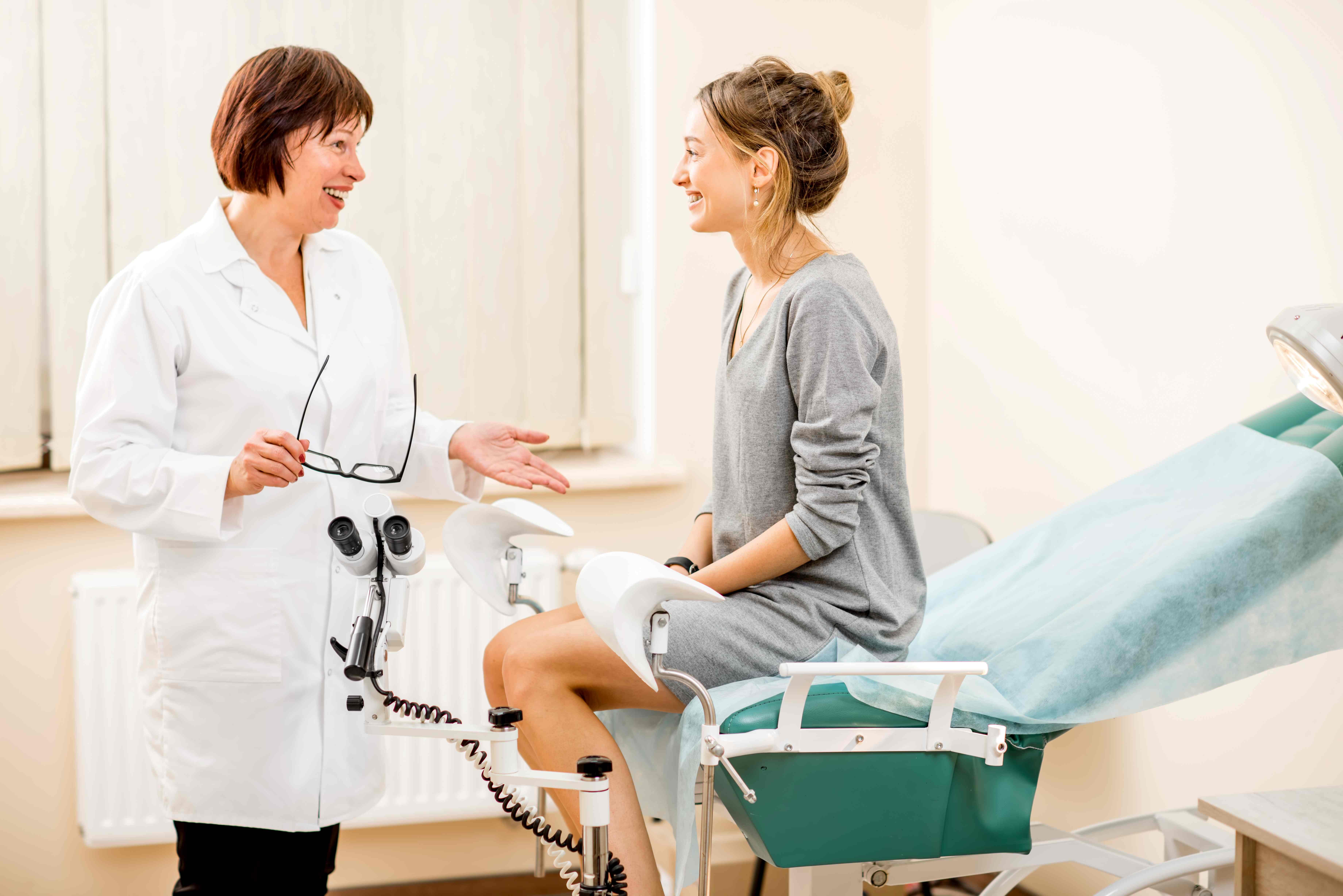 A women having a doctors appointment and smiling with her doctor